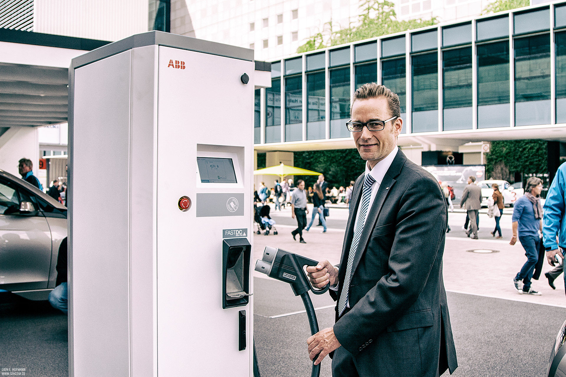 Ein Mann bedient eine ABB Schnelladesaule auf der IAA. Reportagefotgraf Sven E. Hofmann. sehcom.